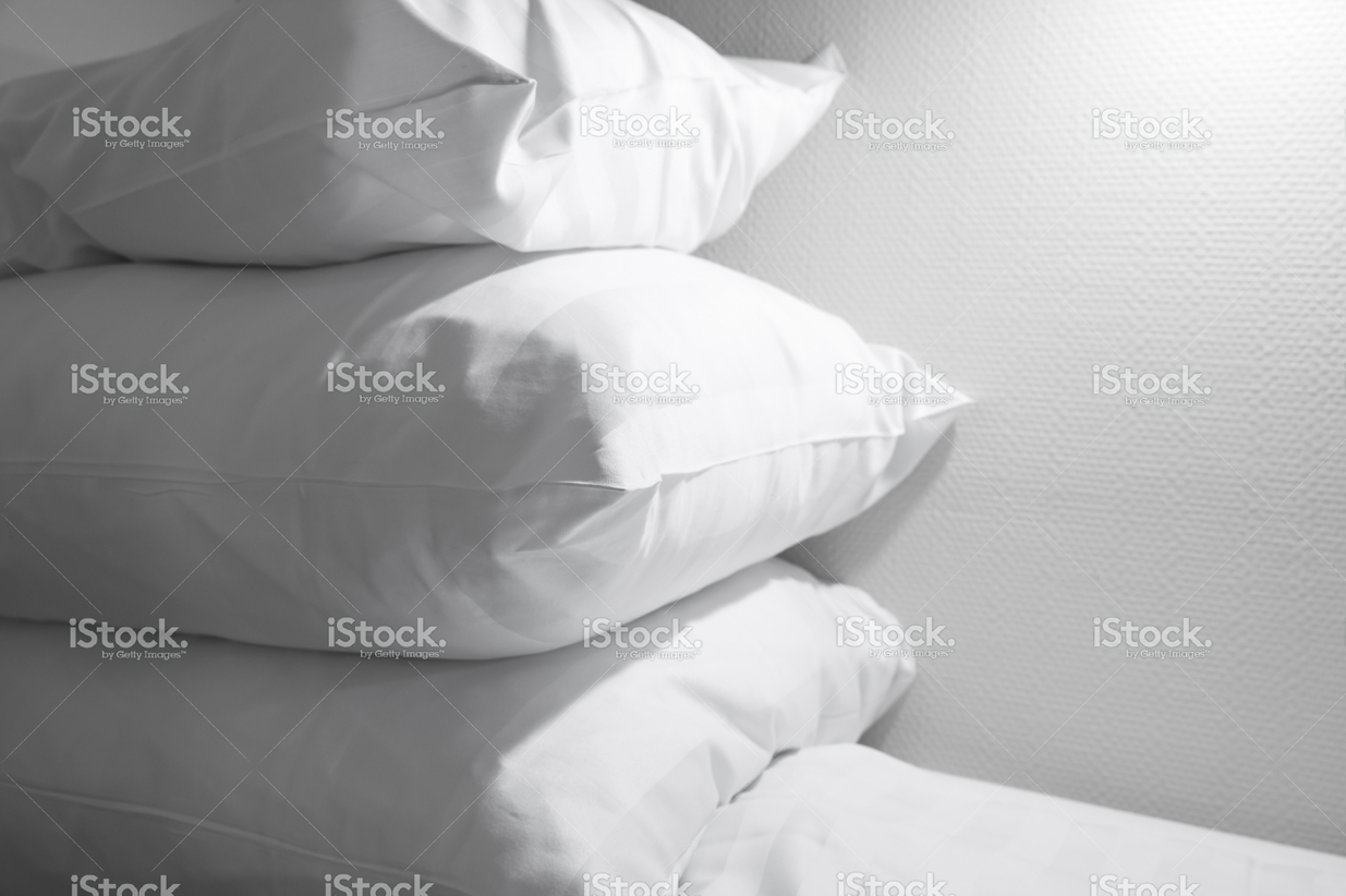 stock-photo-85011483-pile-of-white-pillows-lying-on-empty-bed